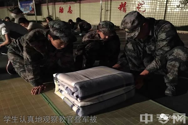 重庆三峡职业技工学校学生认真地观察教官叠军被
